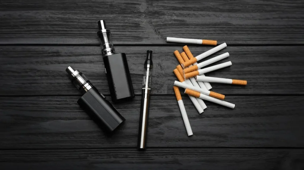 Comparaison entre cigarettes traditionnelles et puffs électroniques sur une table noire - Quel est le meilleur entre cigarette et puff ?